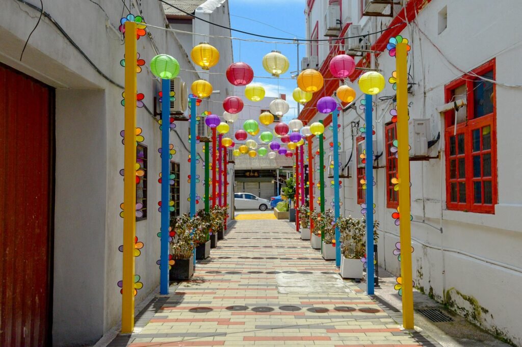 Red Chinese lanterns hanging along a decorated alley in George Town's Chinatown — the visual signature of Penang's Hokkien-Chinese heritage and hawker food street culture