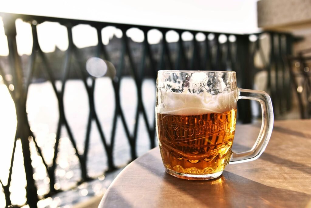 A refreshing lager beer mug outdoors in Prague with a scenic river view of the Vltava