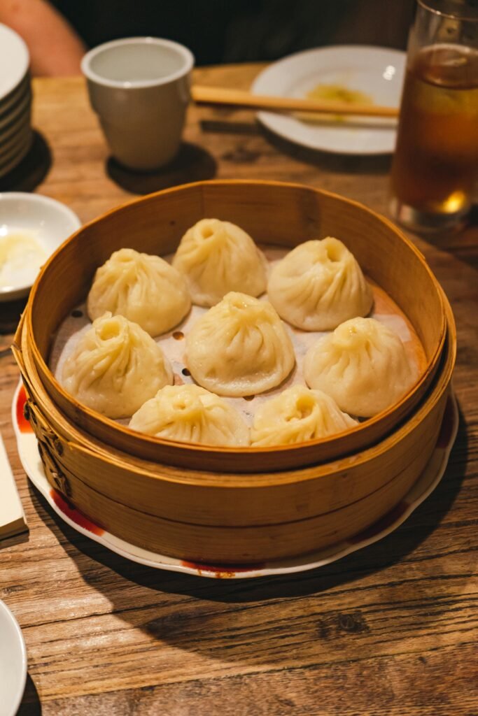 Mouth-watering xiaolongbao soup dumplings in a traditional bamboo steamer — Shanghai's signature dish