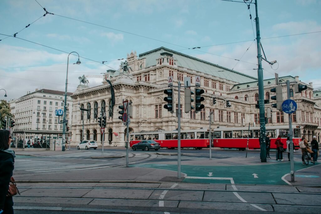 The Vienna State Opera house on the Ringstraße with a passing red tram