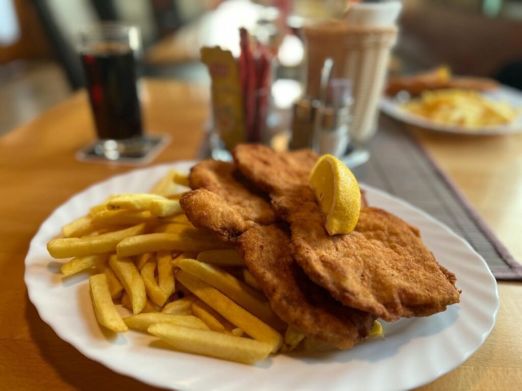 A traditional Wiener Schnitzel served with fries and a slice of lemon
