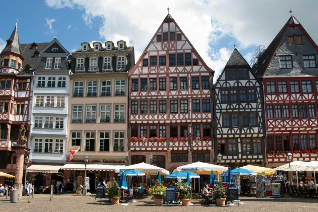 The colourful half-timbered gabled houses of the Ostzeile on Frankfurt's Römerberg square, with cafe umbrellas below