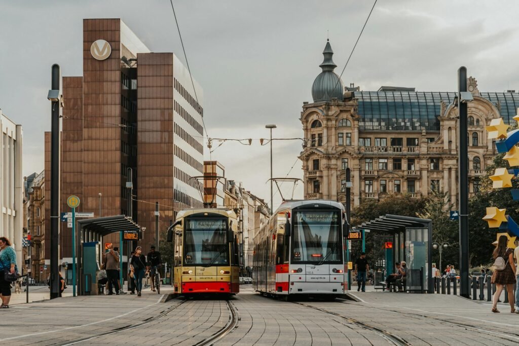 Two RMV trams at a stop in downtown Frankfurt, framed by modern and historic buildings