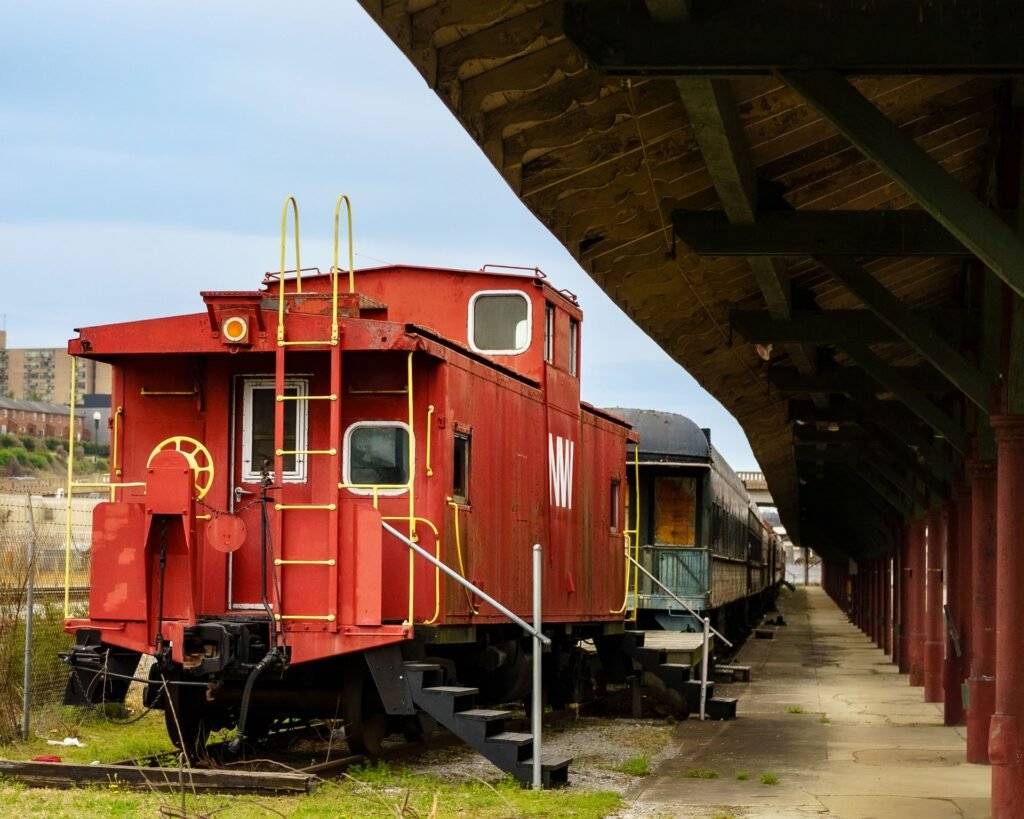 A historic red caboose and rail cars at a covered station platform in Knoxville, a reminder of the city's role as an East Tennessee transportation hub